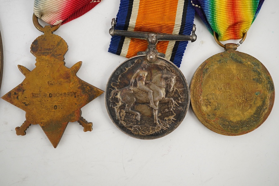 A First World War medal trio and commemorative plaque awarded to PTE. R. Docherty S. GDS. Condition fair.